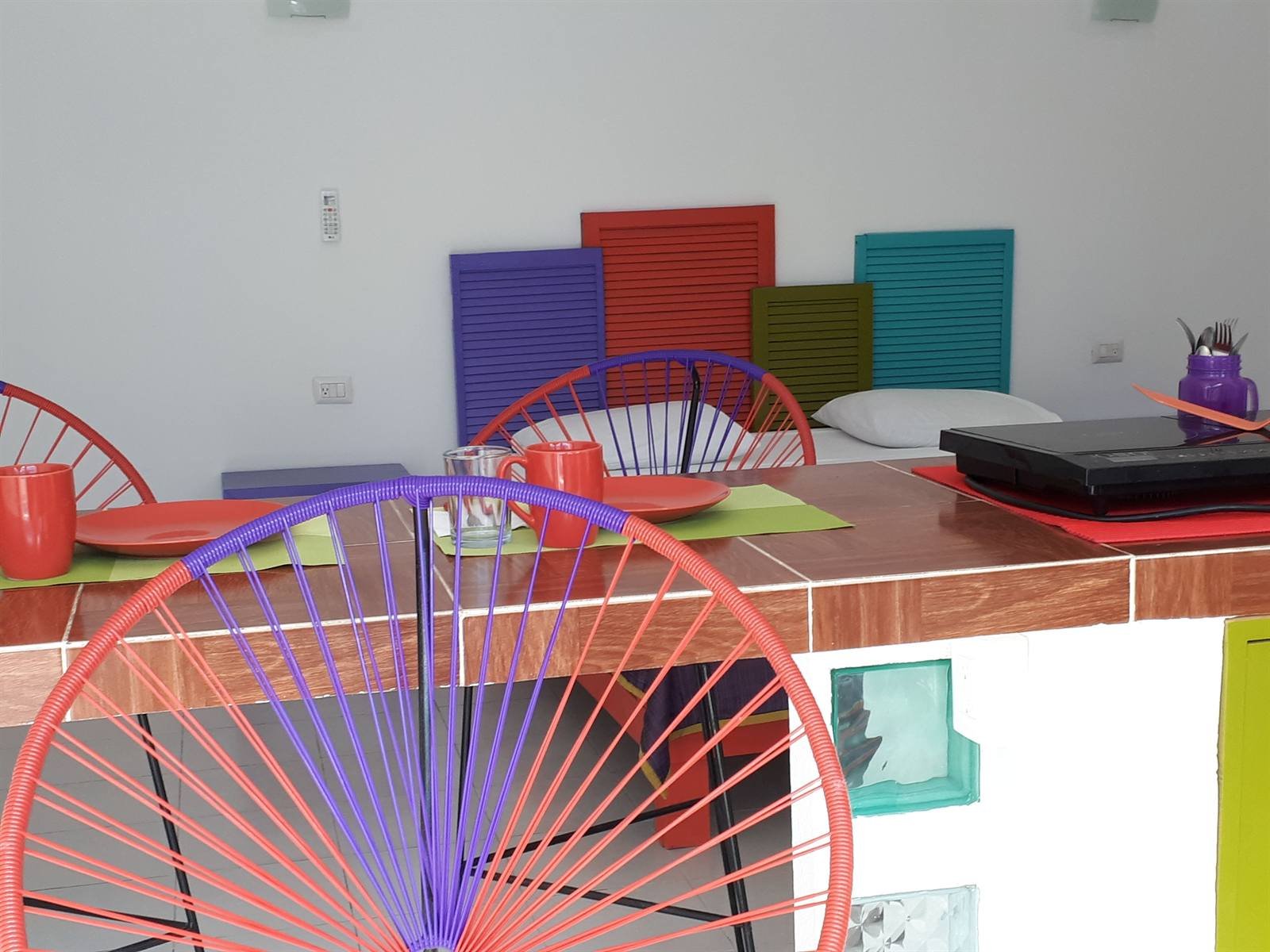 Suite dining area with a wooden table and colorful chairs